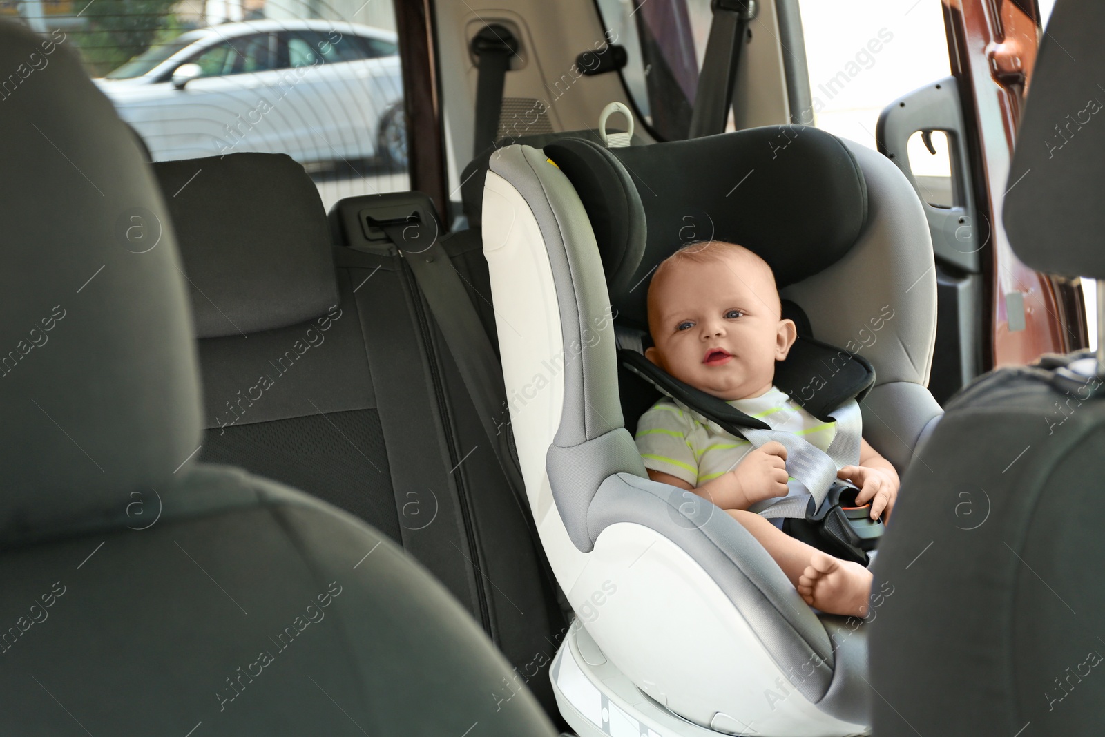 Photo of Little baby in child safety seat inside of car