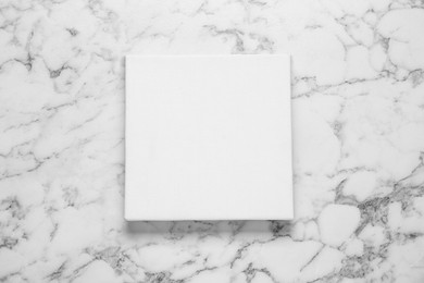 Photo of Blank canvas on white marble background, top view. Space for design