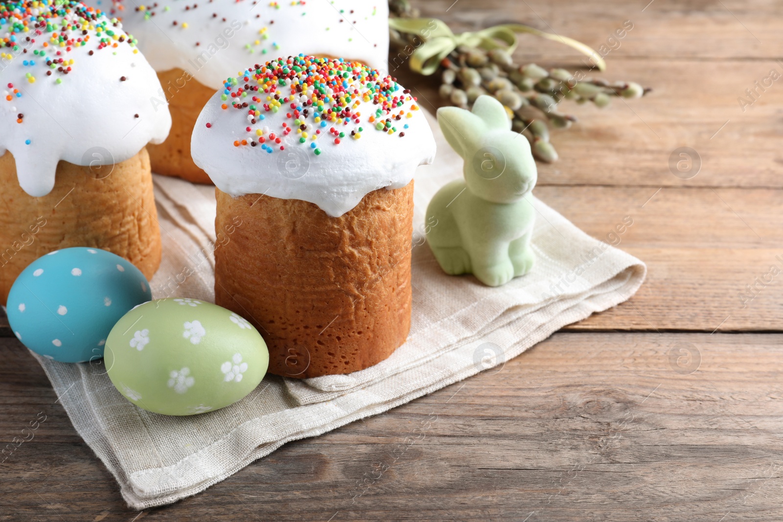 Photo of Beautiful Easter cakes with painted eggs and bunny on wooden table