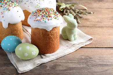 Beautiful Easter cakes with painted eggs and bunny on wooden table