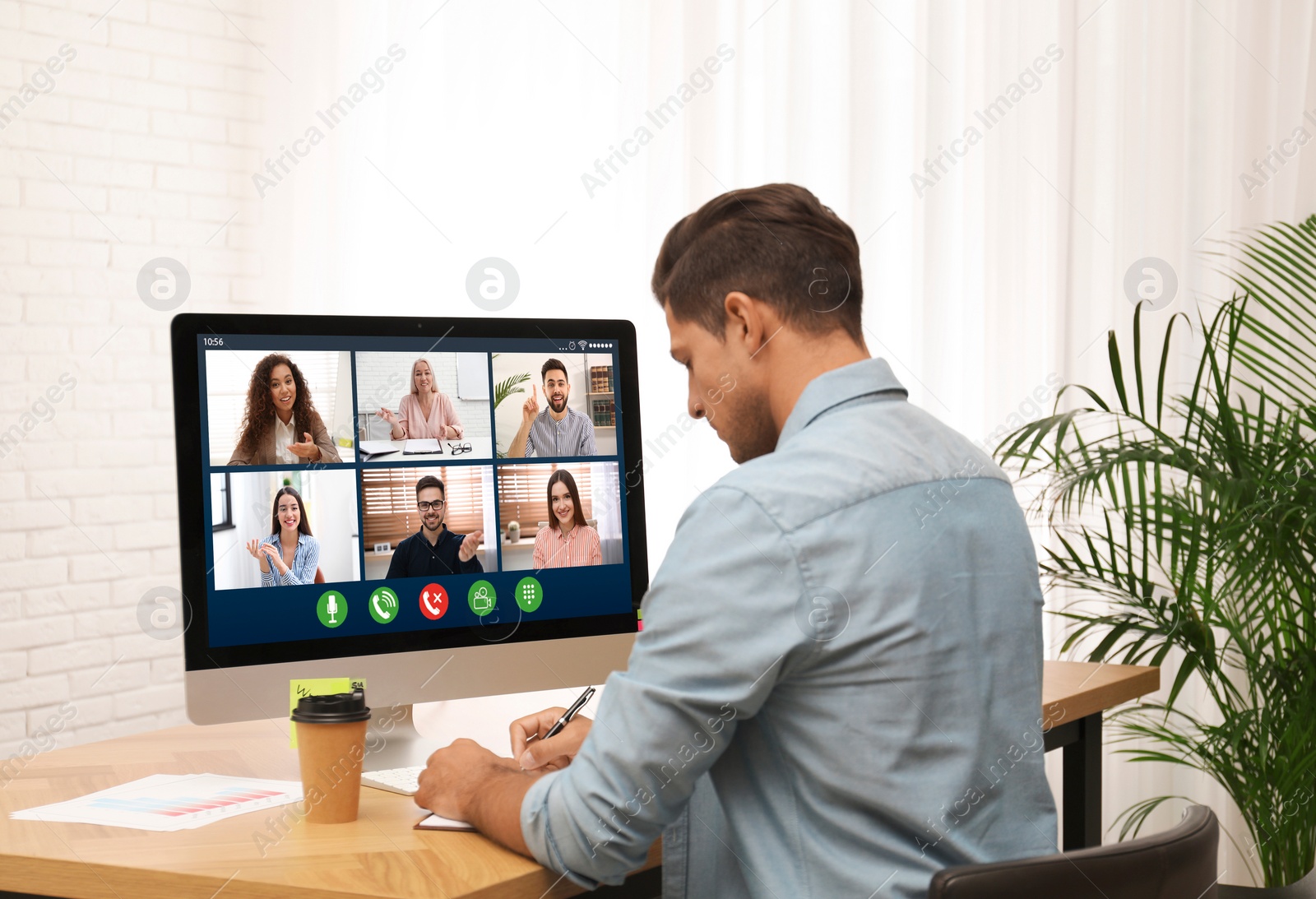 Image of Man having video chat with colleagues at table in office. Team work 