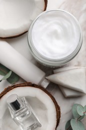 Photo of Different hand care cosmetic products, coconut pieces and eucalyptus branch on table, flat lay