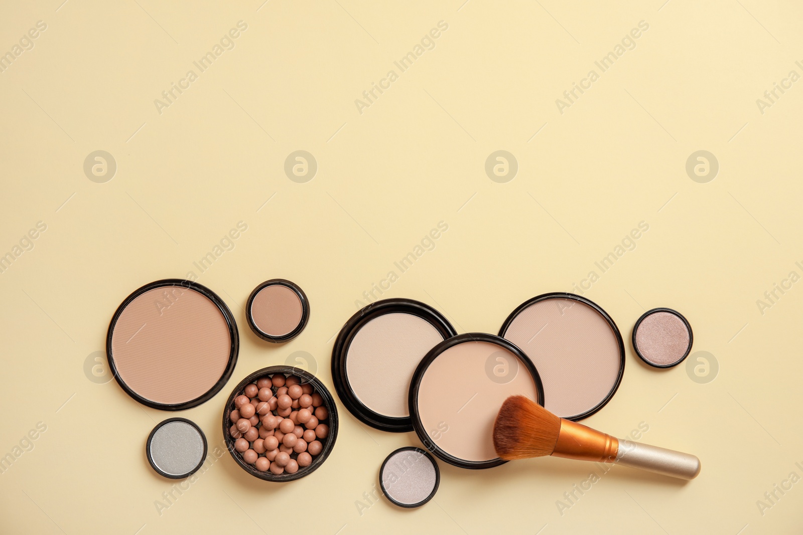 Photo of Flat lay composition with various makeup face powders on color background. Space for text