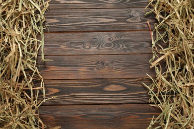 Dried hay on wooden background, flat lay. Space for text