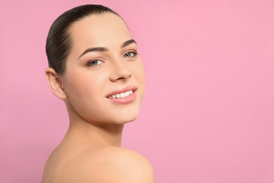 Photo of Portrait of young woman with beautiful face and natural makeup on color background, space for text