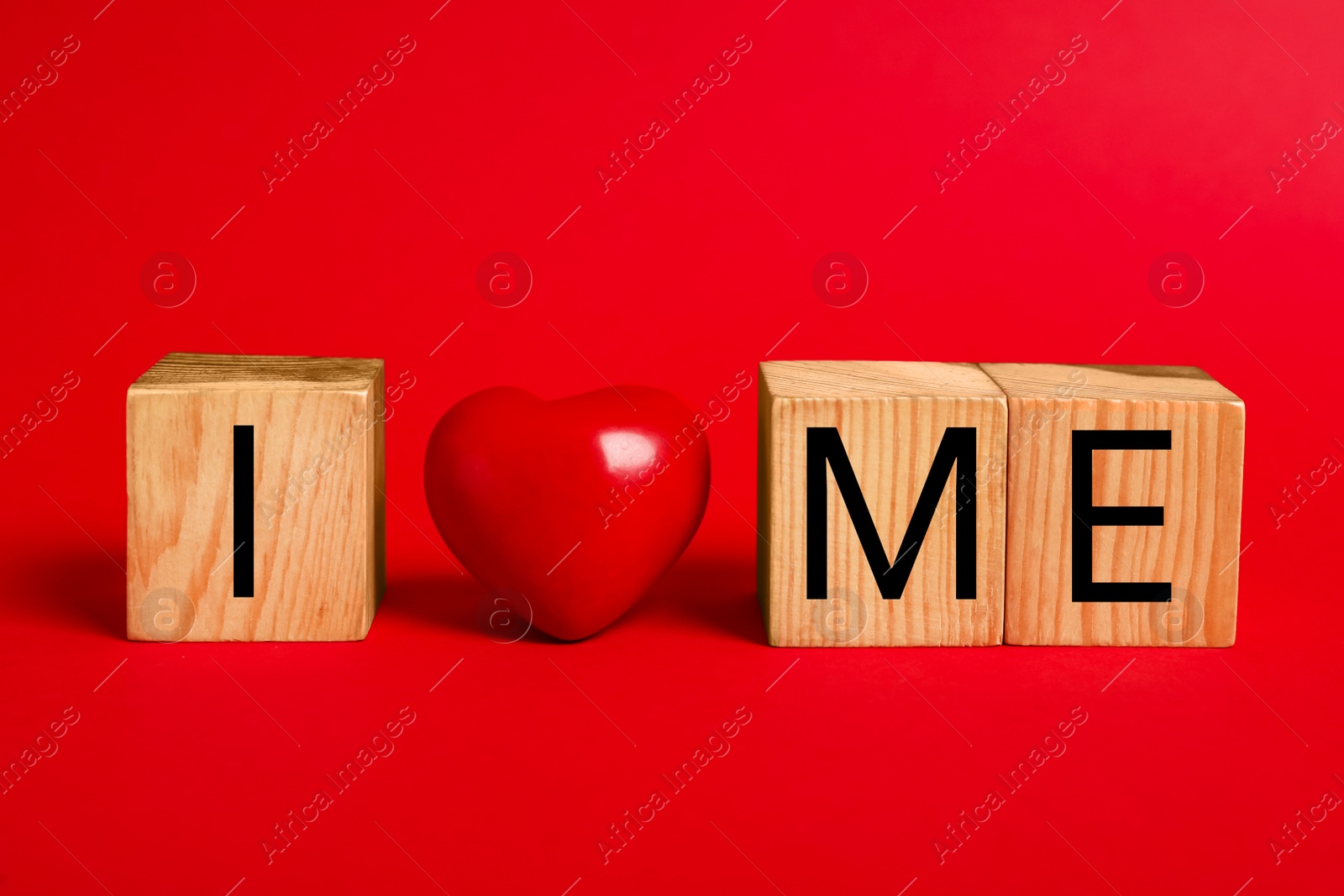 Photo of Phrase I Love Me made with wooden cubes and heart on red background
