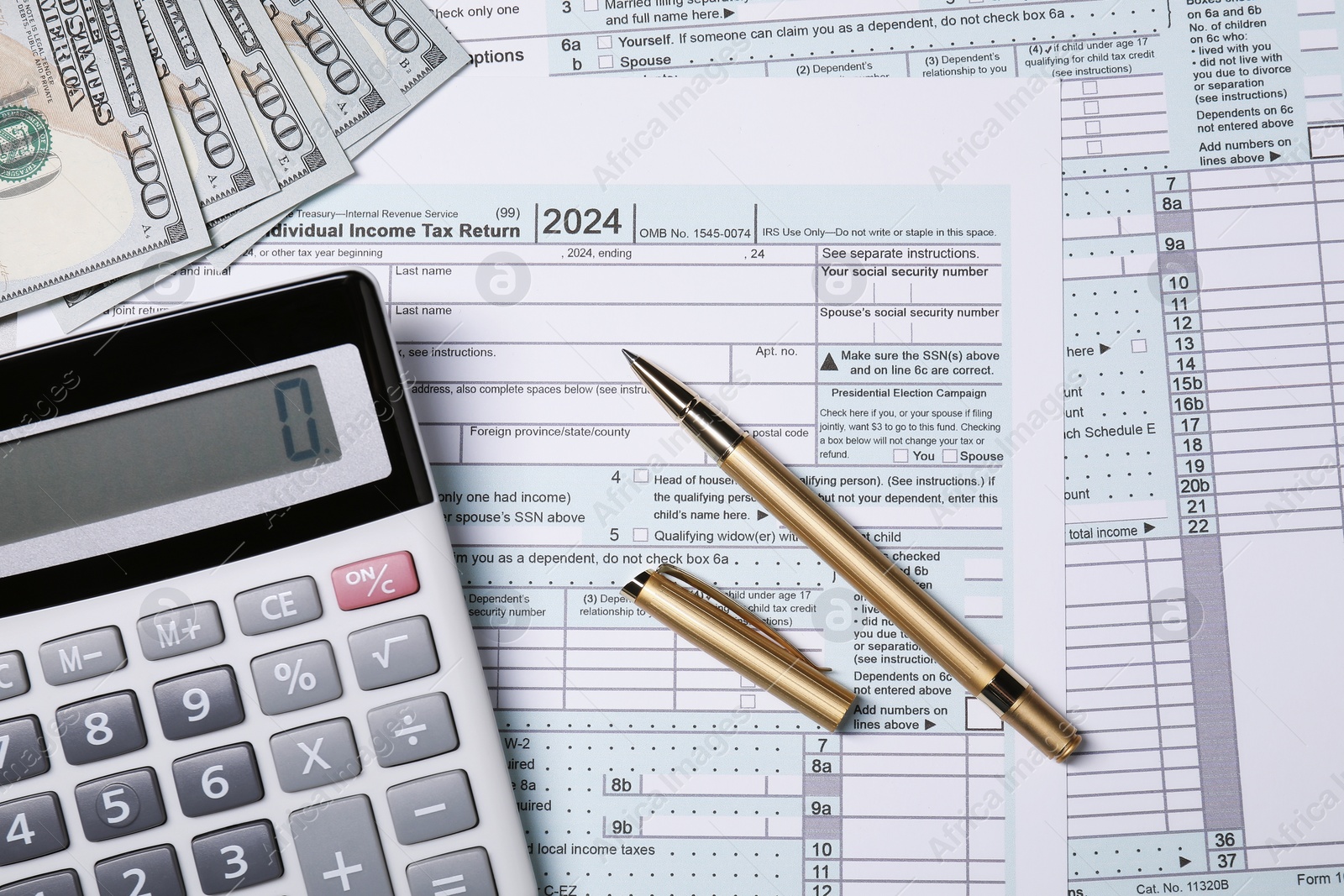 Photo of Tax return forms, pen, calculator and dollar banknotes on table, top view