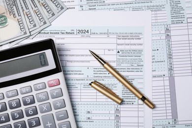 Photo of Tax return forms, pen, calculator and dollar banknotes on table, top view