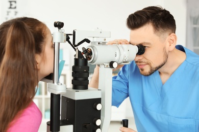 Ophthalmologist examining little girl in clinic