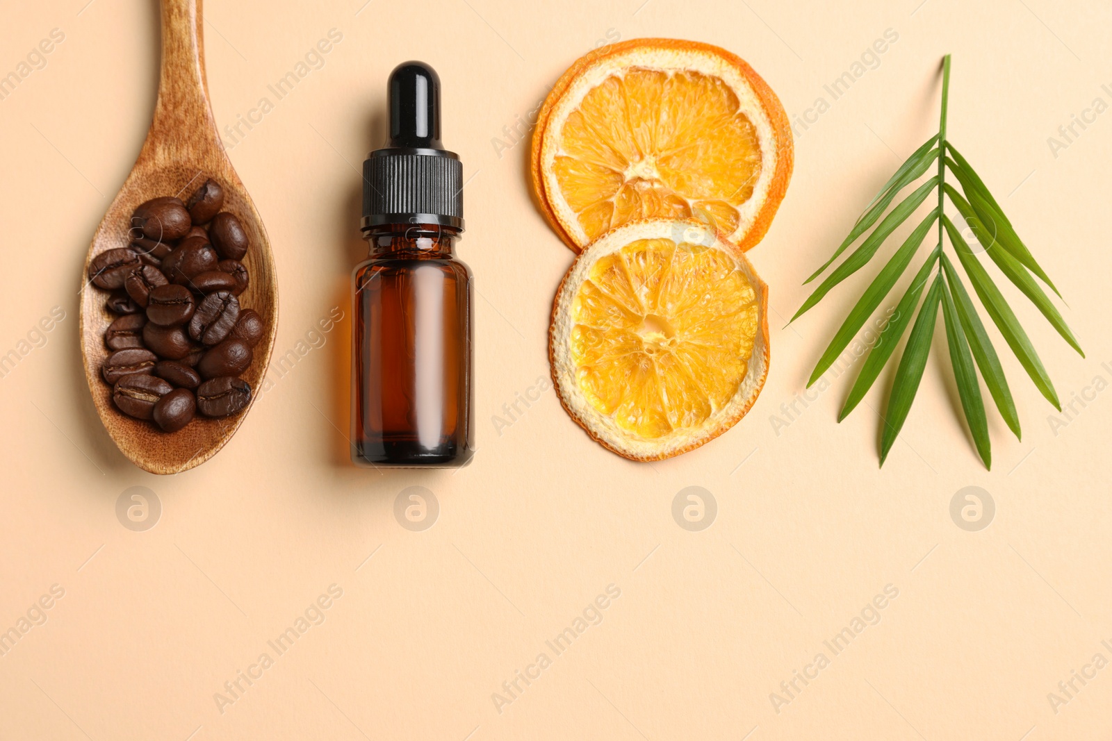 Photo of Bottle of organic cosmetic product, coffee beans, dried orange slices and green leaf on beige background, flat lay. Space for text