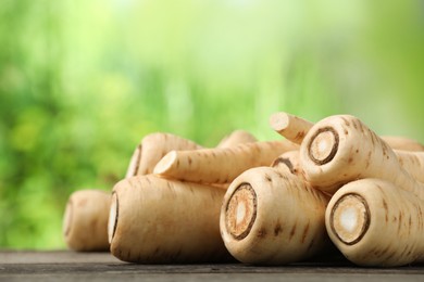 Delicious fresh ripe parsnips on wooden table outdoors, space for text