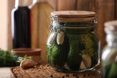 Glass jar with cucumbers, dill and garlic on wooden table. Canning vegetable