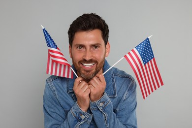 Photo of 4th of July - Independence Day of USA. Happy man with American flags on grey background