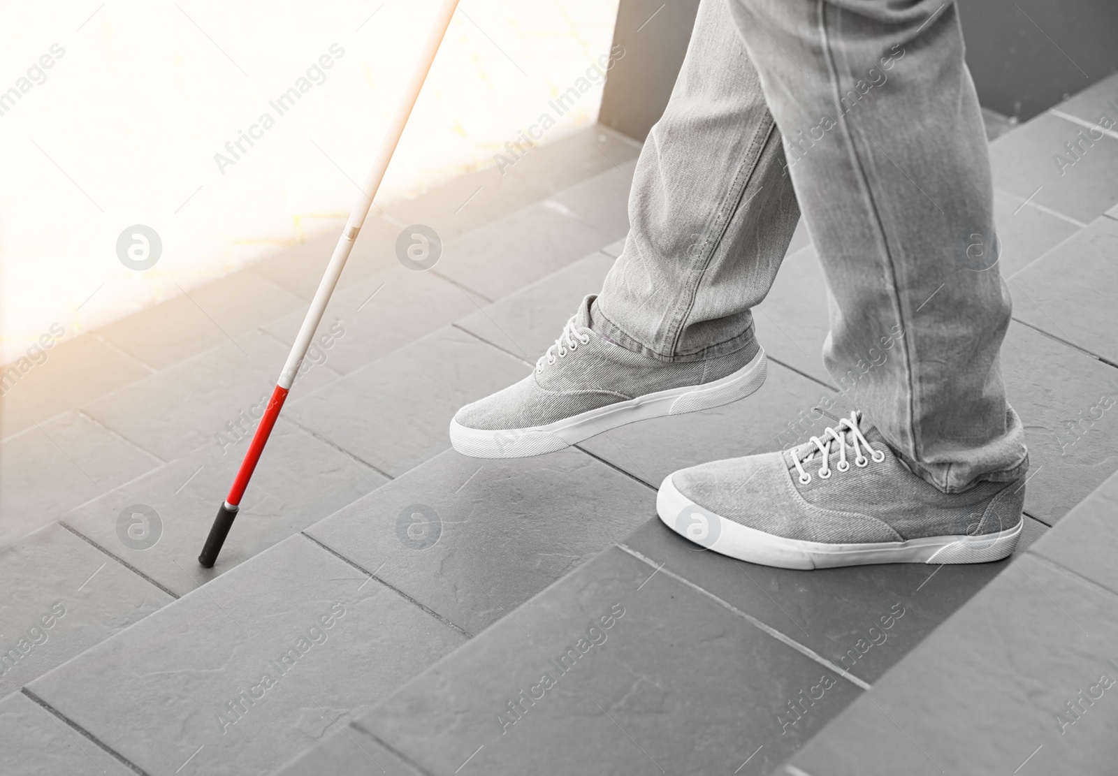 Photo of Blind person with cane going down stairs outdoors, closeup