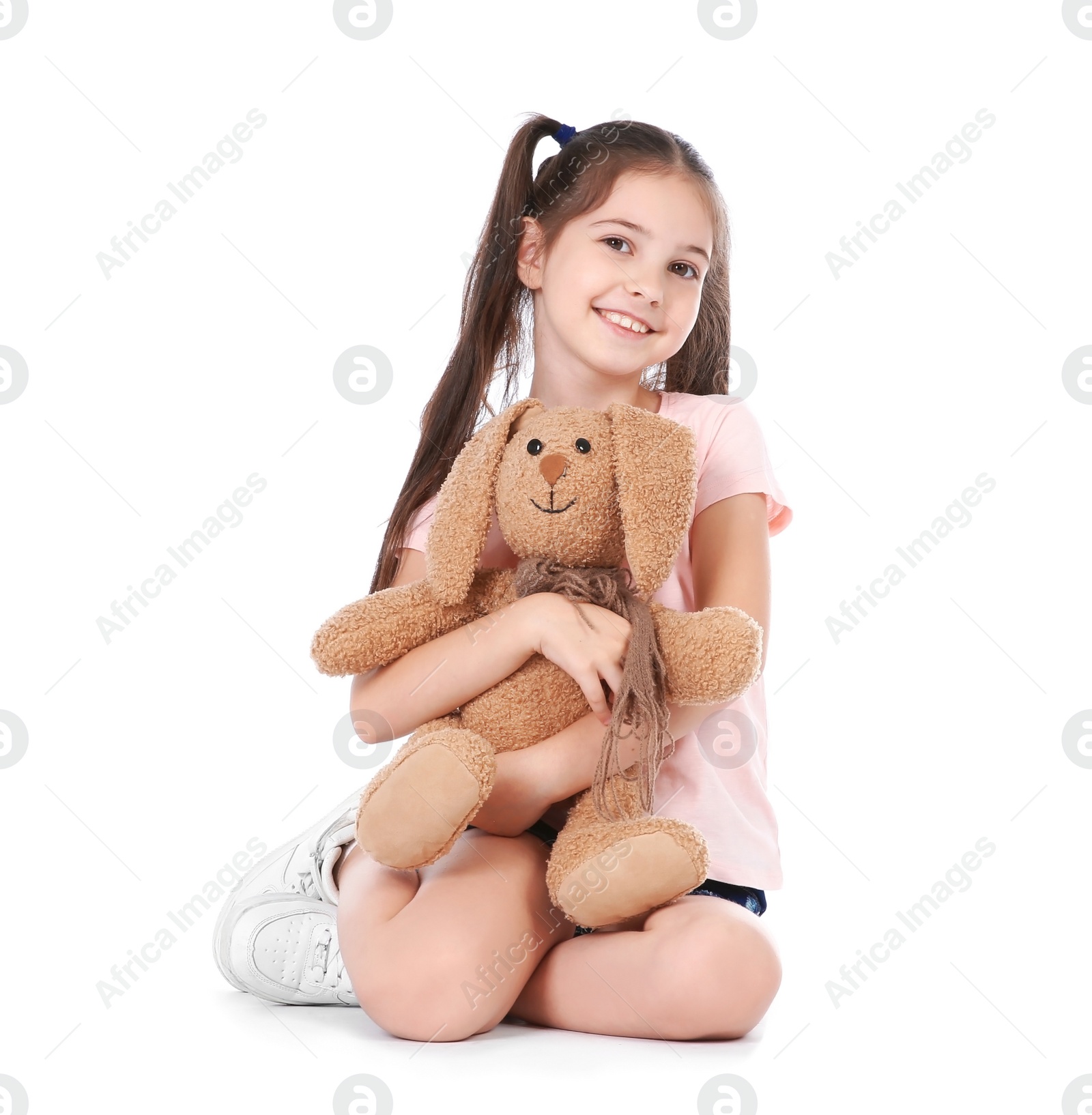 Photo of Playful little child with plush toy on white background. Indoor entertainment