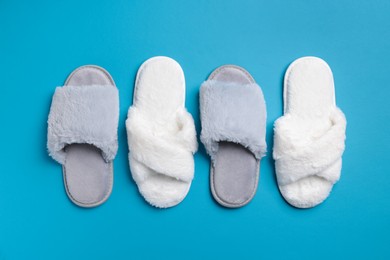 Photo of Different soft fluffy slippers on light blue background, flat lay