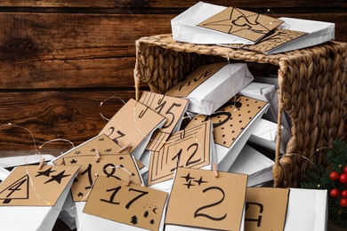 Paper bags and garland on wooden background, closeup. Christmas advent calendar