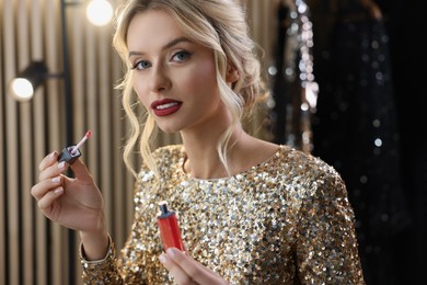 Beautiful makeup. Attractive woman applying lipstick in dressing room