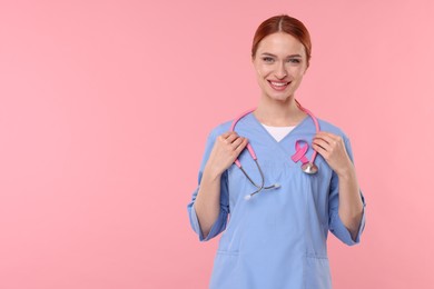 Photo of Mammologist with pink ribbon on color background, space for text. Breast cancer awareness