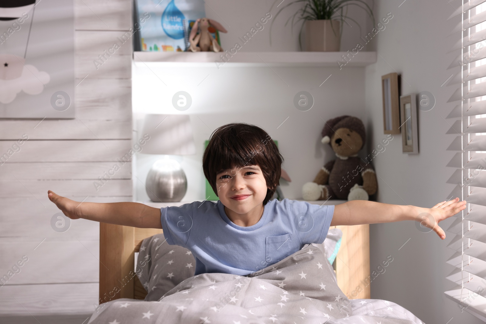 Photo of Cute little boy in bed at home