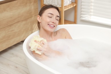 Photo of Woman taking bath with shower gel in bathroom