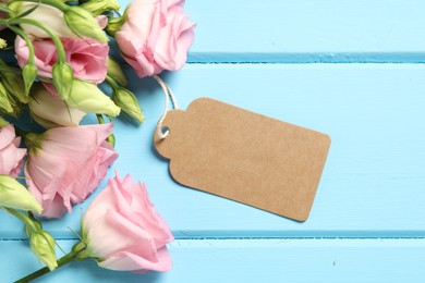 Happy Mother's Day. Beautiful flowers with blank card on light blue wooden table, flat lay