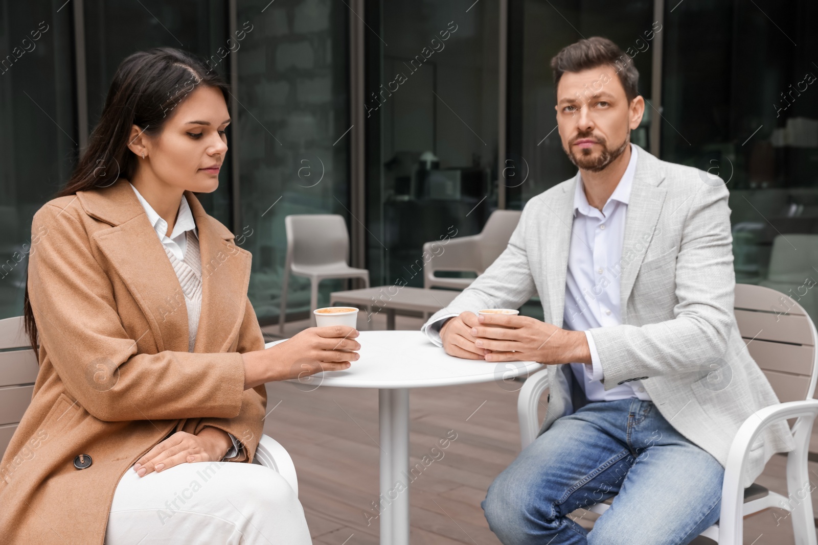 Photo of Upset arguing couple in outdoor cafe. Relationship problems