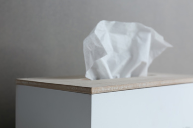 Photo of Holder with paper tissues on grey background, closeup