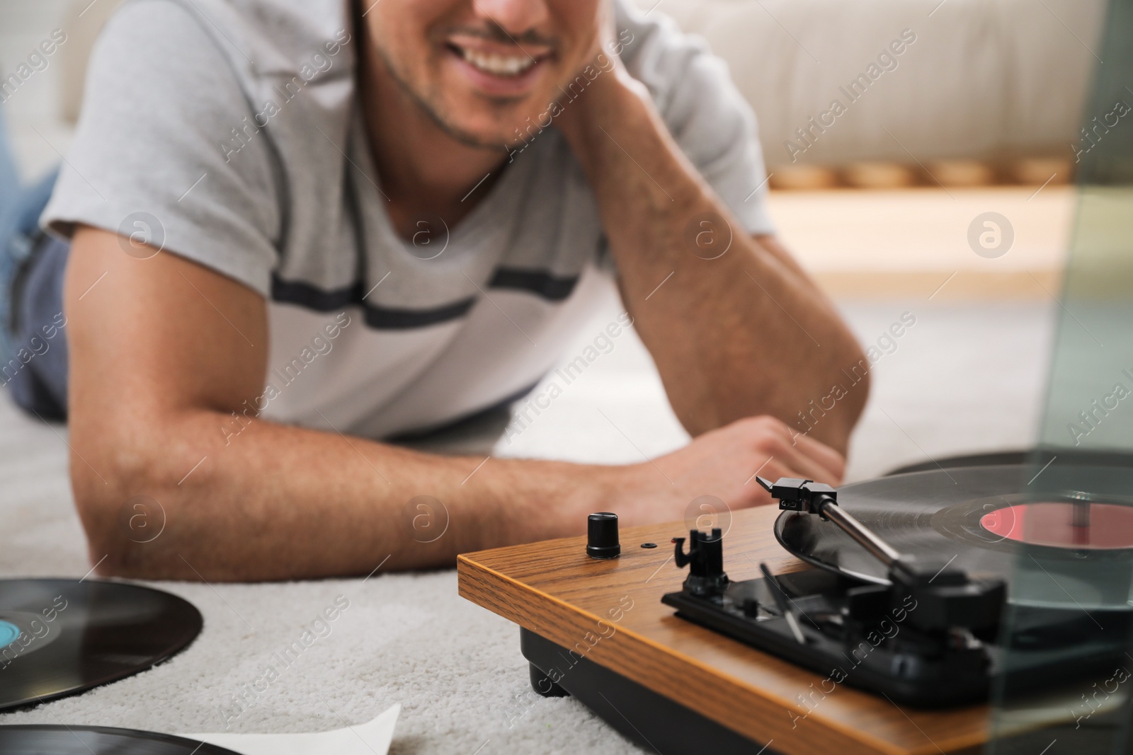 Photo of Happy man using turntable at home, closeup