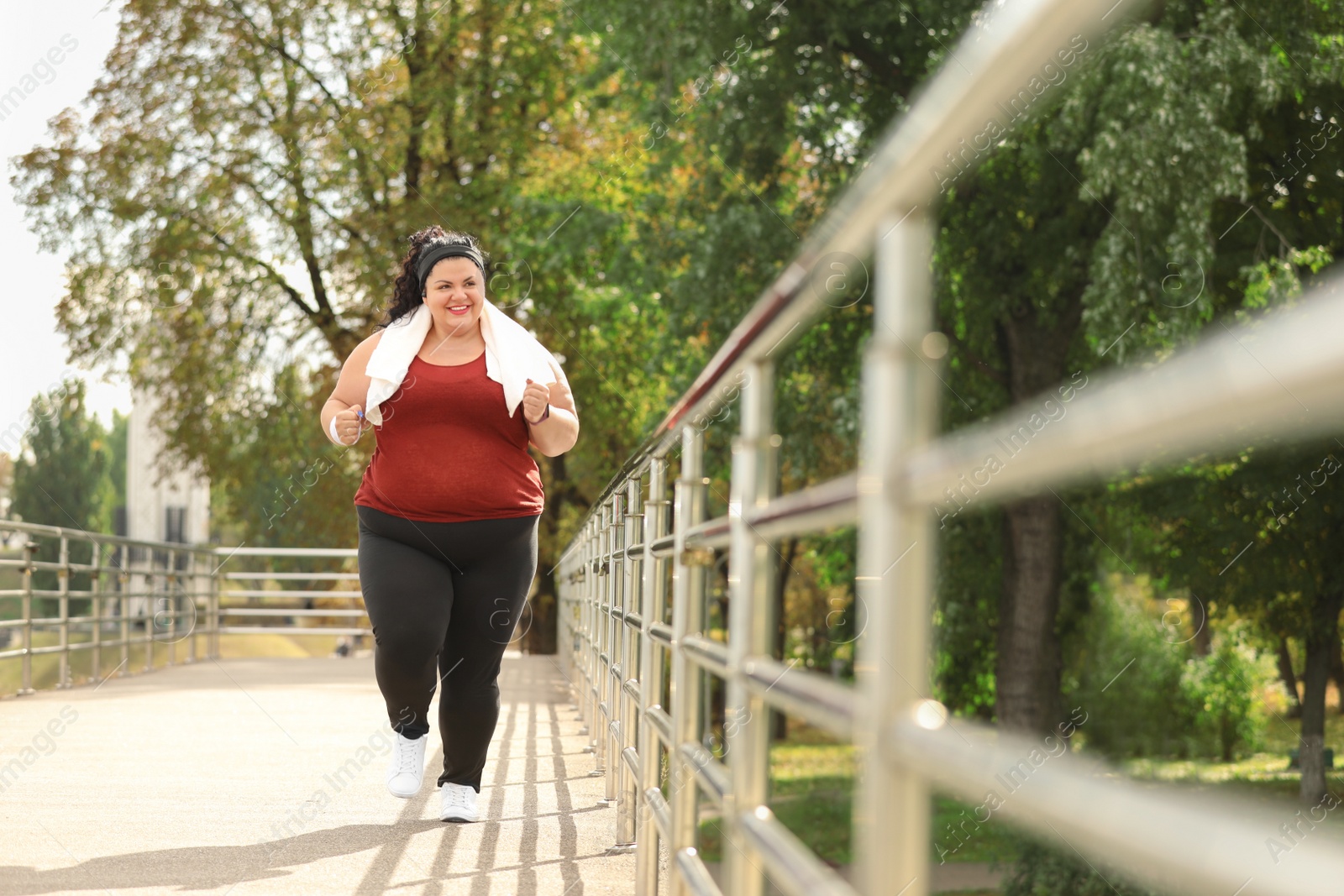 Photo of Beautiful overweight woman running outdoors. Fitness lifestyle