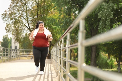 Photo of Beautiful overweight woman running outdoors. Fitness lifestyle
