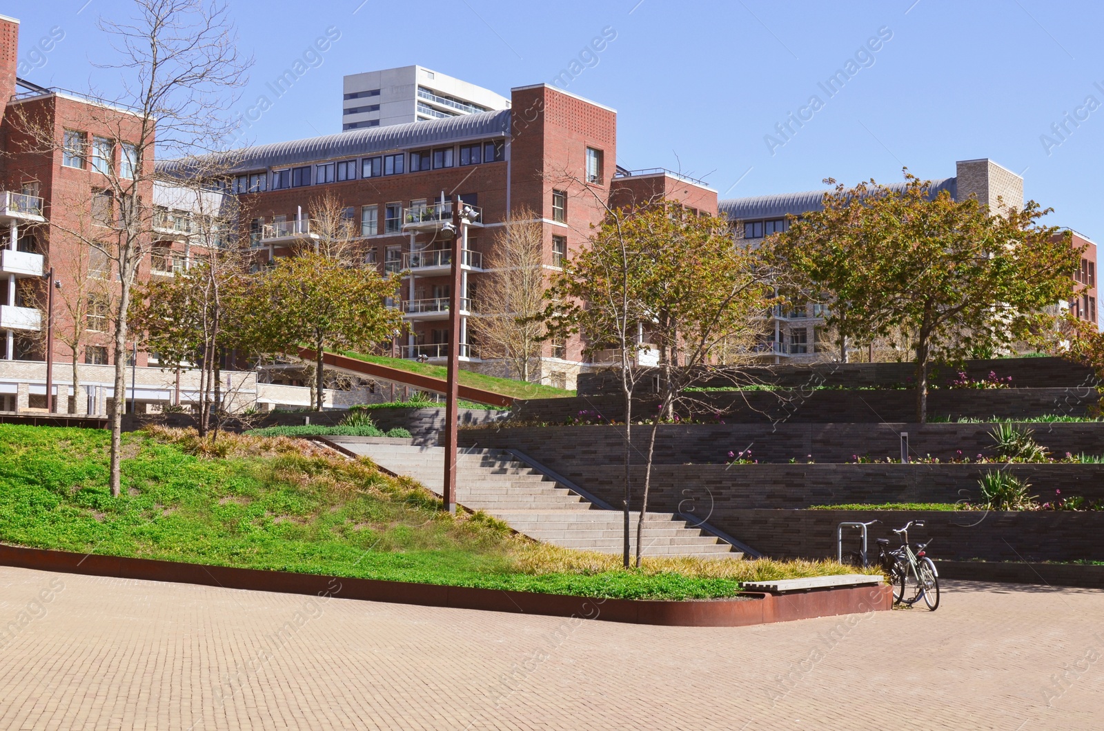 Photo of Cityscape with beautiful apartment buildings and cozy square on sunny spring day