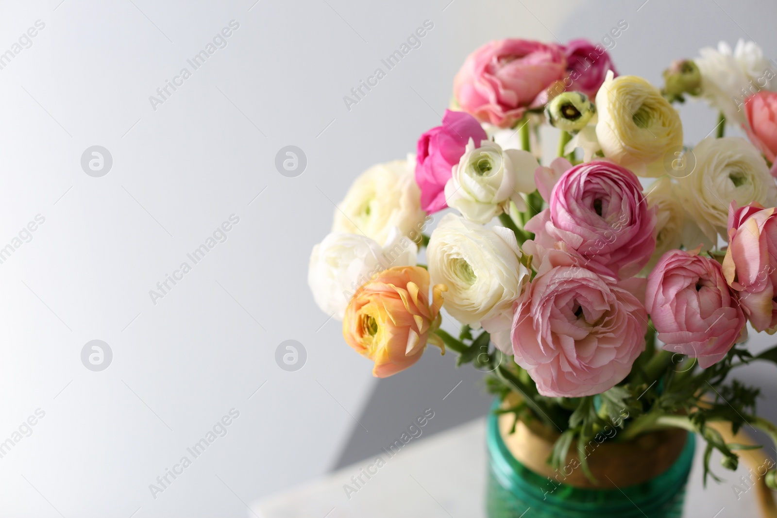 Photo of Bouquet of beautiful ranunculuses on light grey background. Space for text