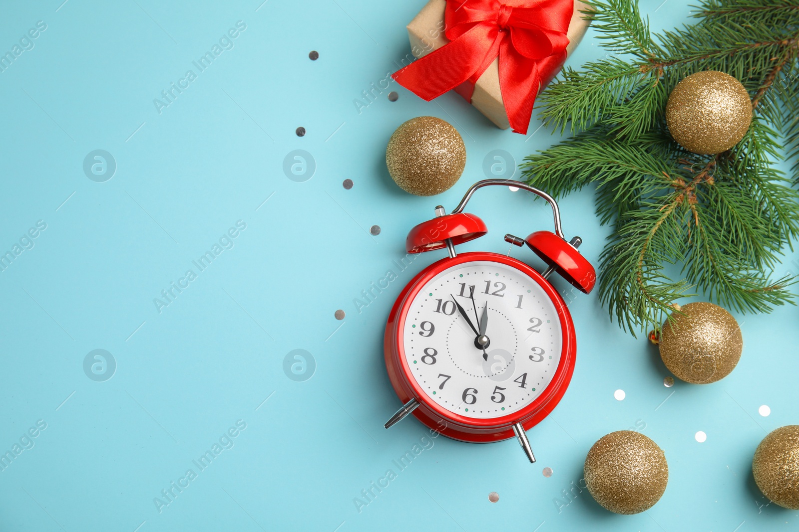 Photo of Flat lay composition with alarm clock, gift box and beautiful decorations on color background. Christmas countdown