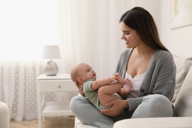 Young woman with her little baby on sofa at home
