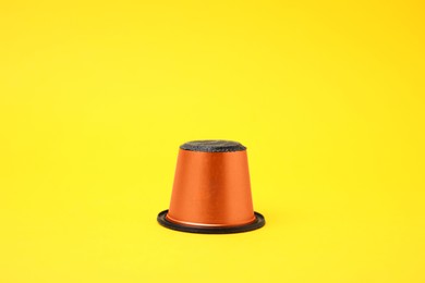 One plastic coffee capsule on yellow background