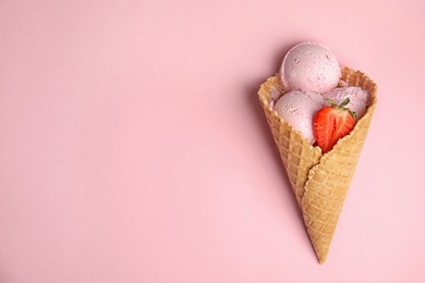 Delicious ice cream in waffle cone on color background, top view. Space for text