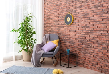 Photo of Stylish room interior with armchair and potted ficus