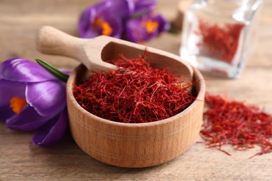 Dried saffron and crocus flowers on wooden table, closeup