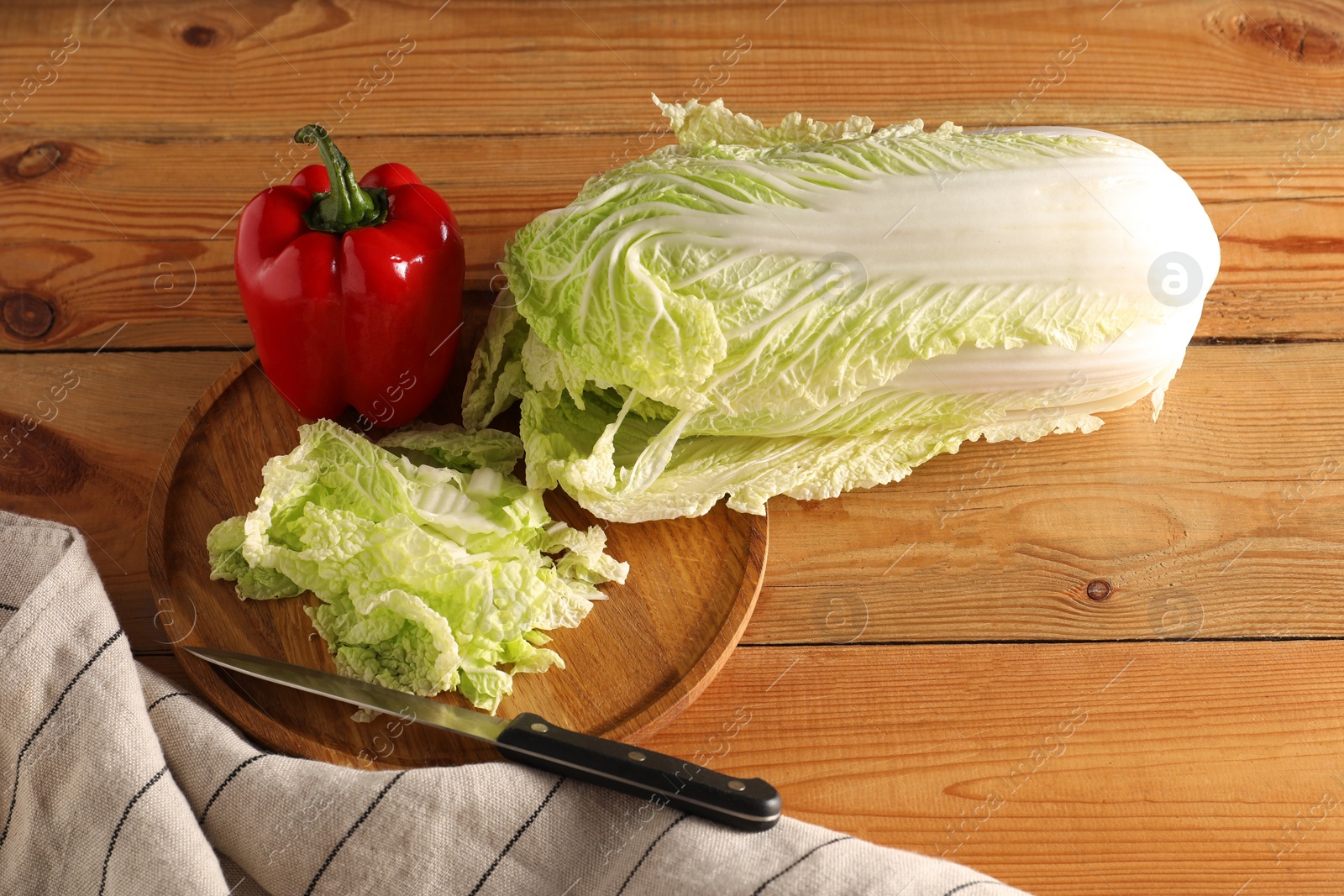 Photo of Fresh Chinese cabbage, pepper and knife on wooden table, above view