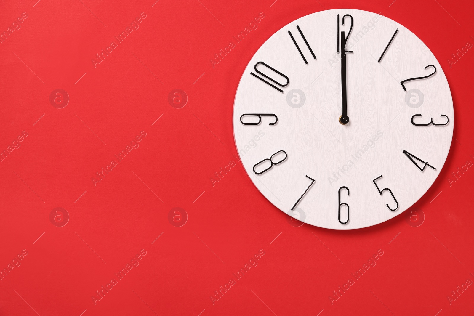 Photo of Modern clock on red background, top view. Space for text