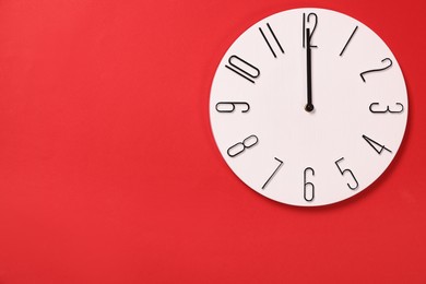 Modern clock on red background, top view. Space for text