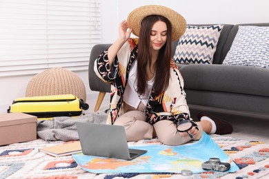 Photo of Travel blogger with magnifying glass and map planning trip at home