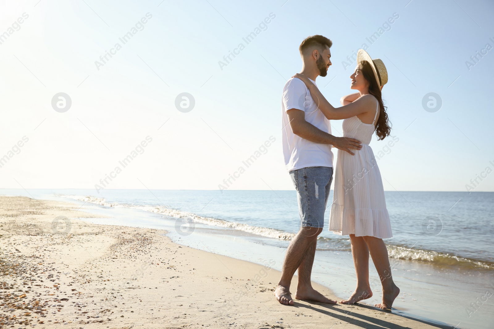 Photo of Happy young couple on beach near sea. Honeymoon trip