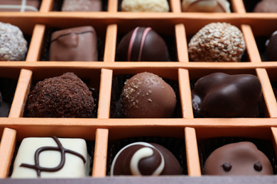 Photo of Different delicious chocolate candies in box, closeup