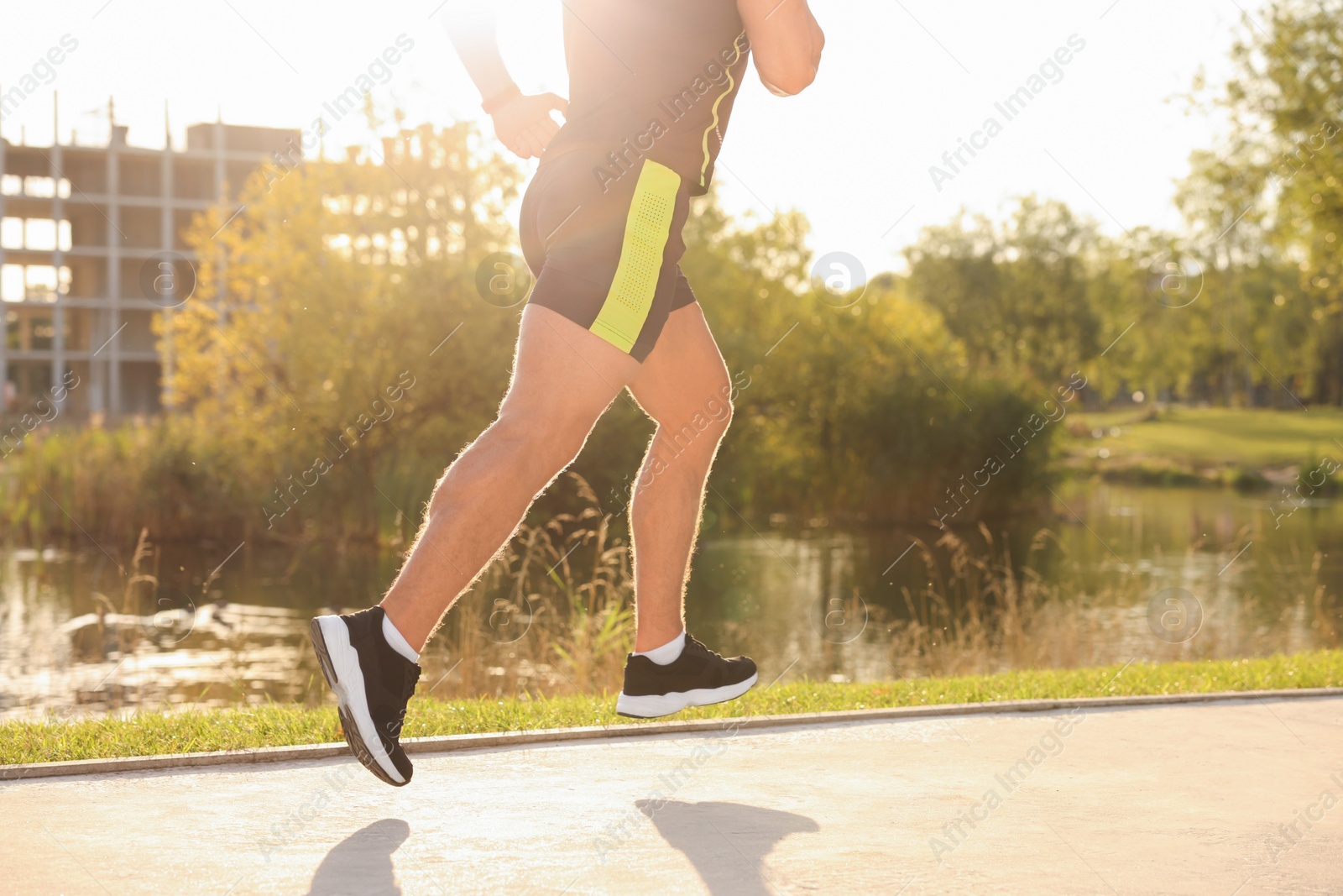 Photo of Man running near pond in park, closeup