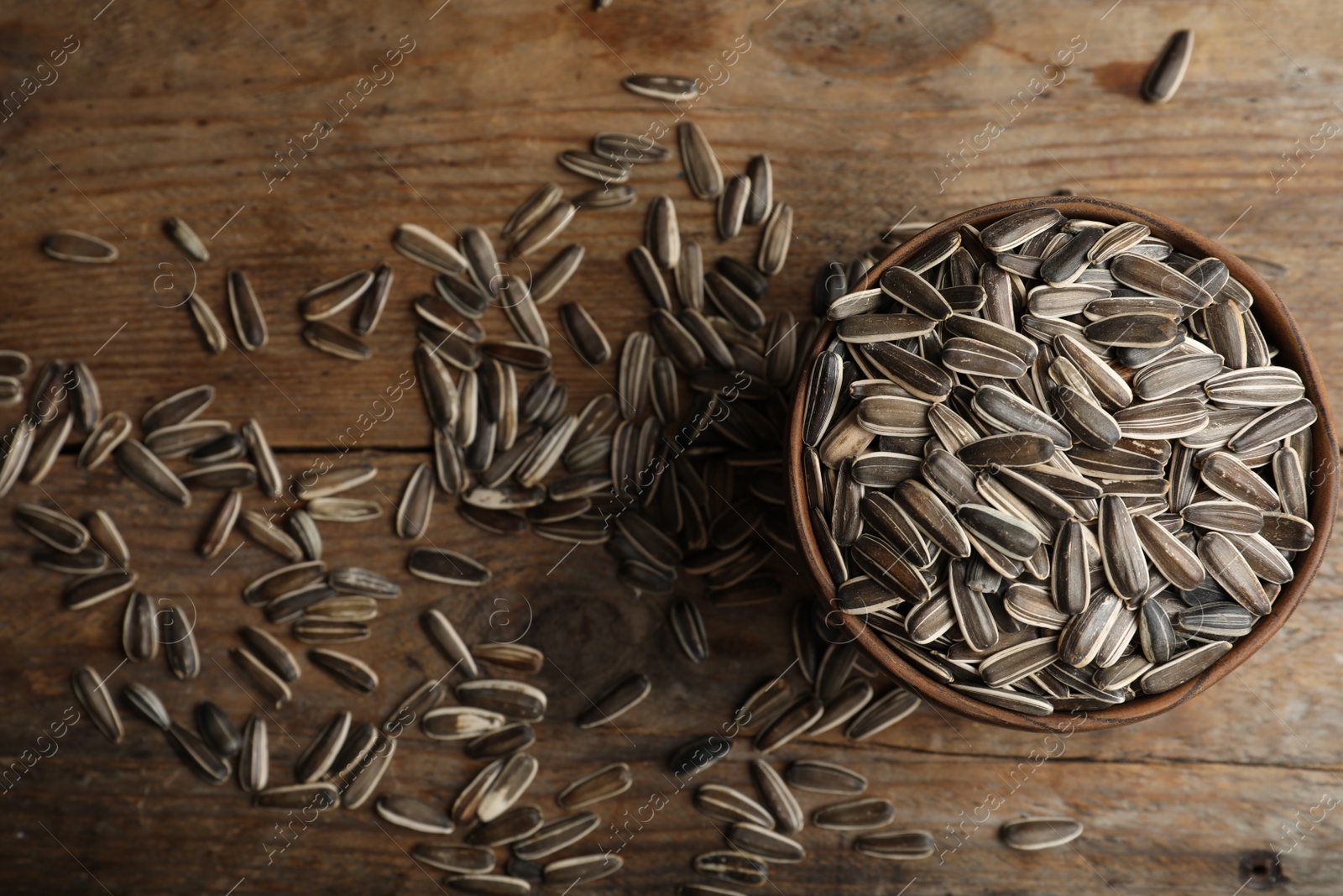 Photo of Organic sunflower seeds on wooden table, flat lay