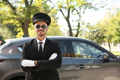 Young handsome driver standing near luxury car. Chauffeur service