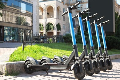 Many modern electric scooters parked on city street. Rental service