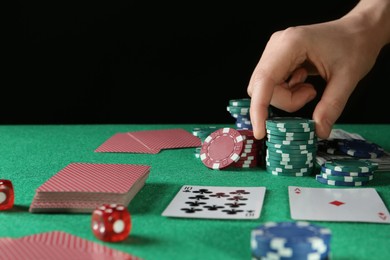 Photo of Man taking casino chips while playing poker at table, closeup. Space for text